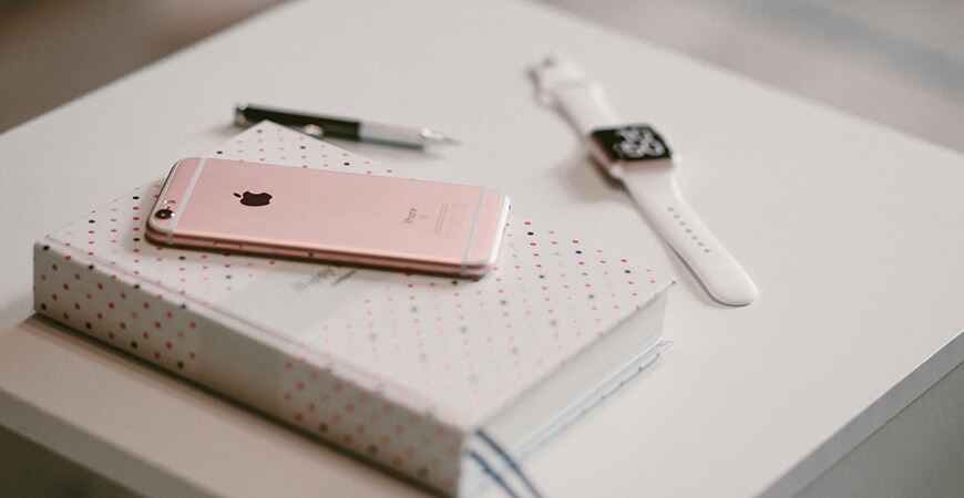 A book with some papers and an apple watch