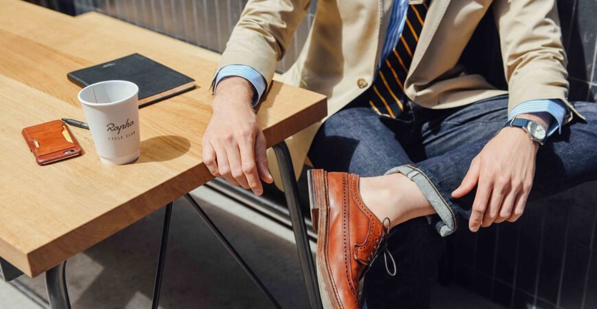 A person sitting at a table with his feet on the desk.